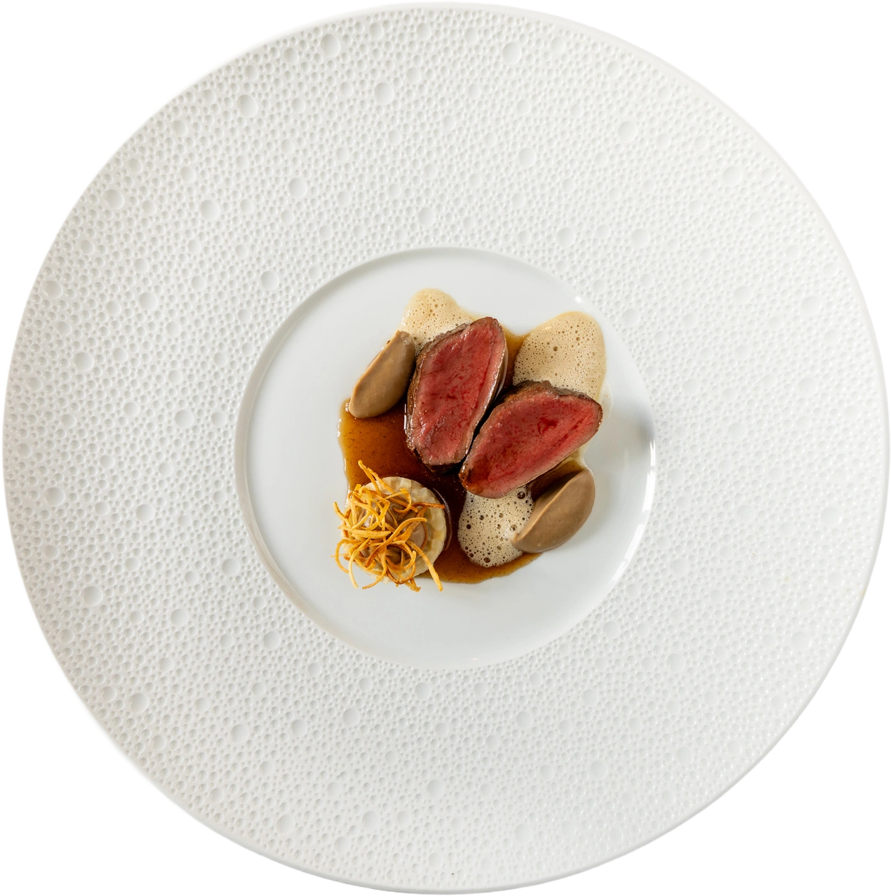 Rosé gebakken wildfilet met quenelles, schuim en jus op wit bord met reliëfrand.